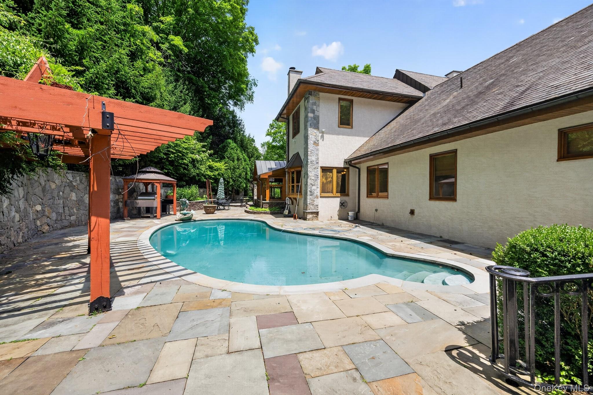 23 Inningwood Road Ossining, NY 10562 - Photo 5 of 50 Curved swimming pool bordered by extensive flagstone patio