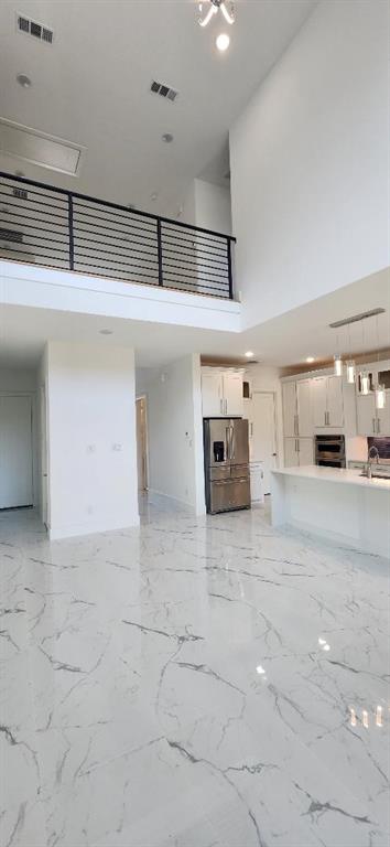3338 Sylvan Avenue Dallas, TX 75212 - Photo 3 of 13 Unfurnished living room featuring a high ceiling, light marble finish floors, and recessed lighting