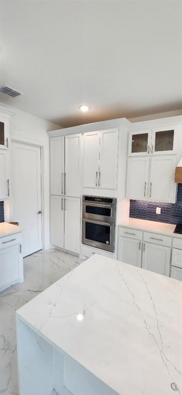 3338 Sylvan Avenue Dallas, TX 75212 - Photo 10 of 13 Kitchen with glass insert cabinets, white cabinets, light stone counters, and recessed lighting