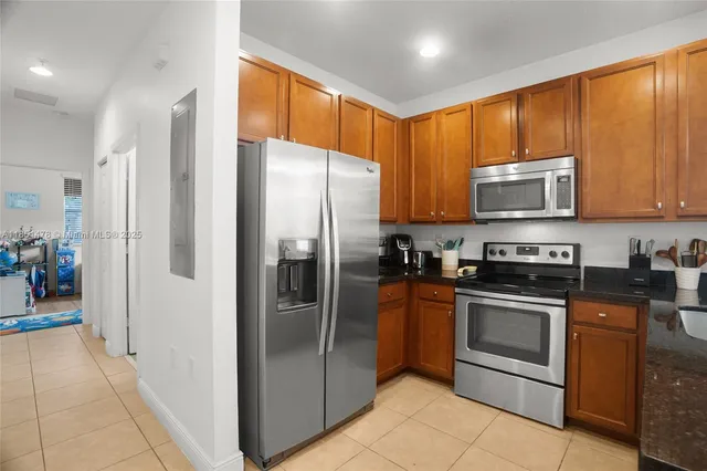 a kitchen with stainless steel appliances granite countertop a refrigerator and a stove top oven