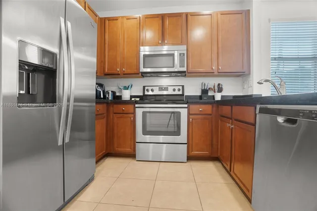 a kitchen with stainless steel appliances granite countertop a door and a refrigerator
