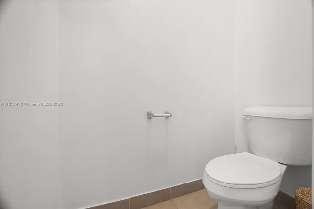 a white toilet sitting next to a white wall