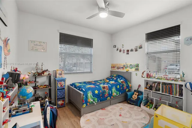 a bedroom with furniture a baby crib and a window