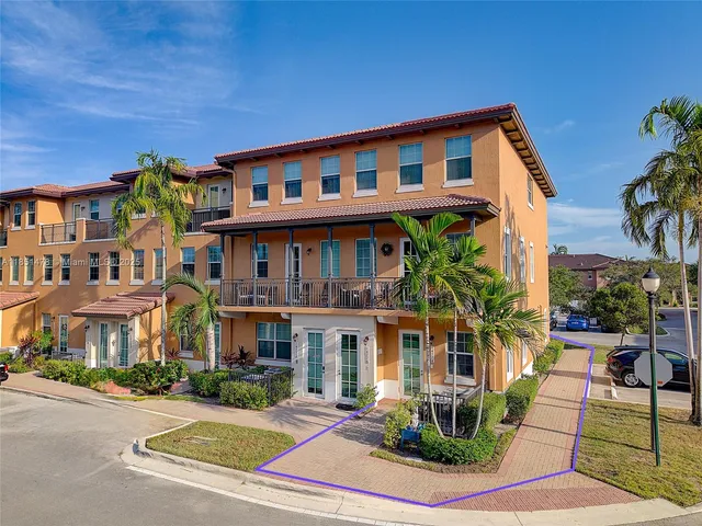 a front view of a residential apartment building with a yard