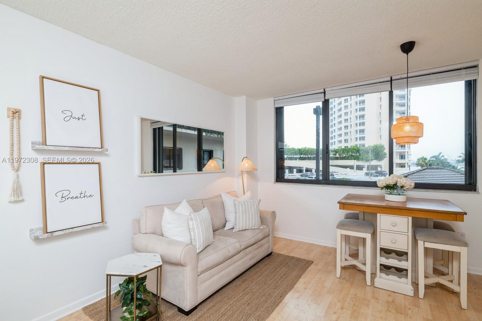 540 Brickell Key Drive, Unit 504 Miami, FL 33131 - Photo 11 of 31 a living room with furniture a flat screen tv and a large window