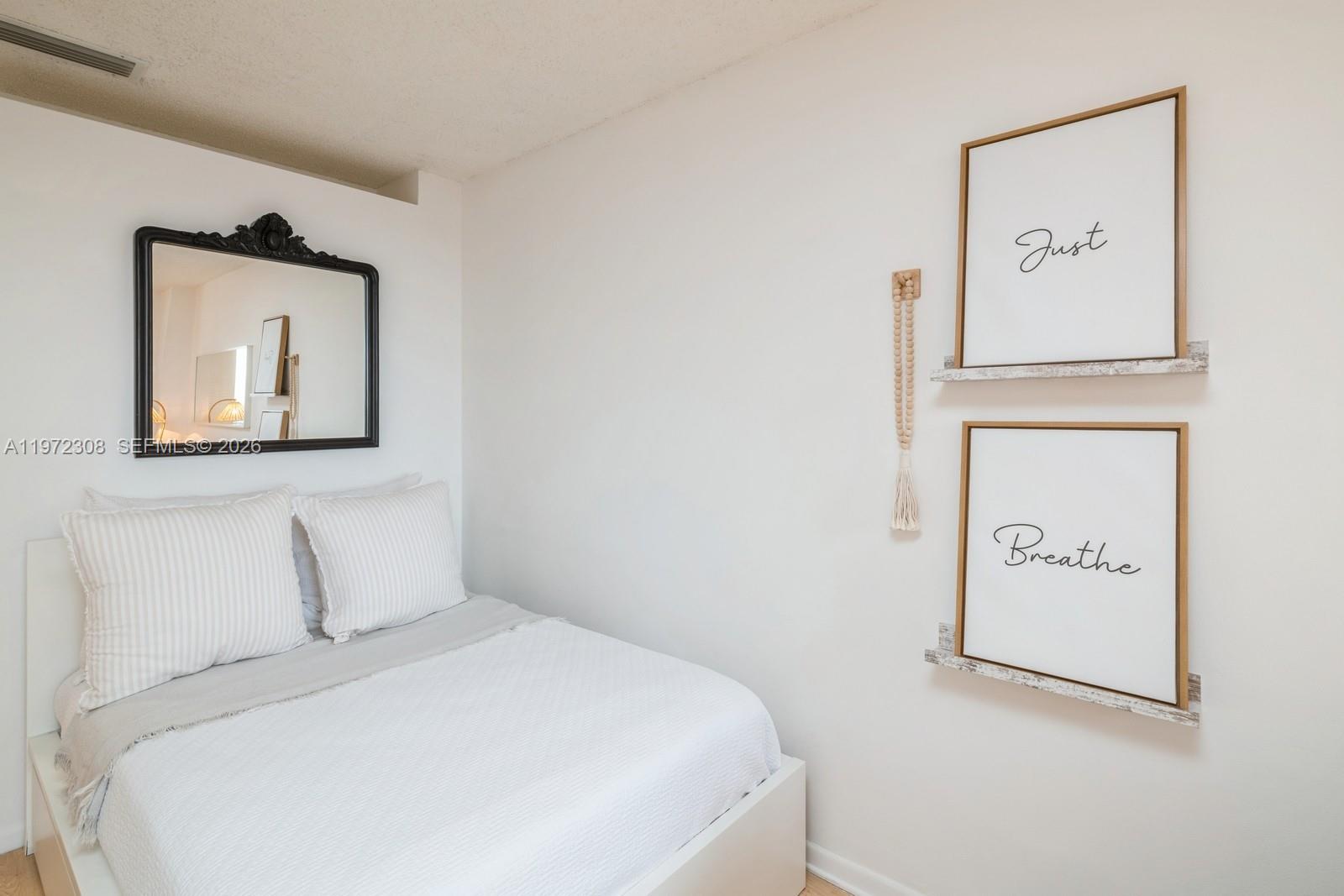 540 Brickell Key Drive, Unit 504 Miami, FL 33131 - Photo 14 of 31 a bedroom with a bed and a painting on the wall