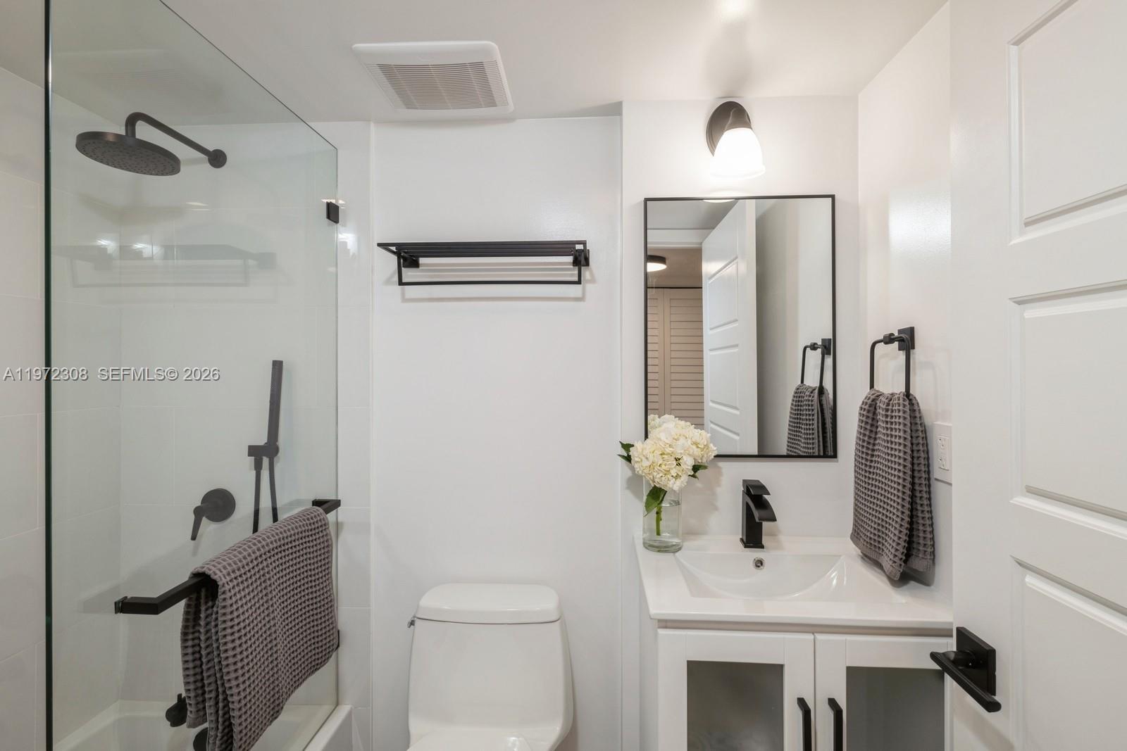 540 Brickell Key Drive, Unit 504 Miami, FL 33131 - Photo 18 of 31 a bathroom with a sink vanity granite toilet and a mirror