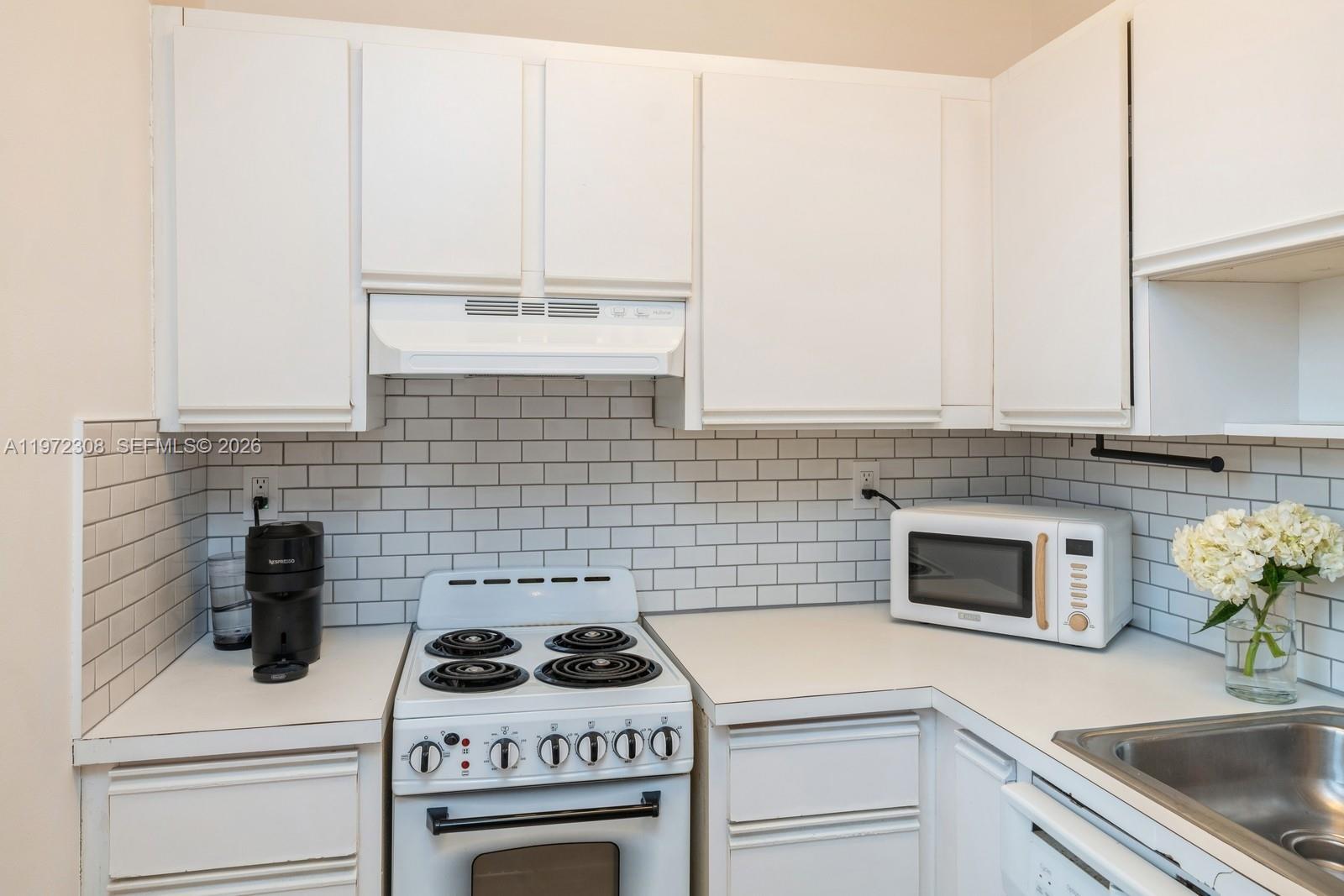 540 Brickell Key Drive, Unit 504 Miami, FL 33131 - Photo 22 of 31 a kitchen with a stove and white cabinets
