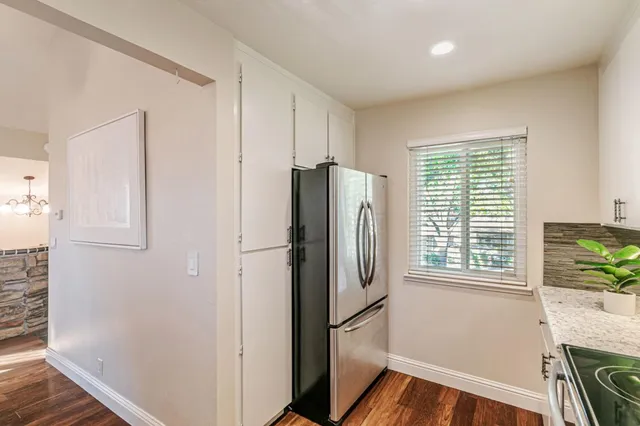 a kitchen with stainless steel appliances a refrigerator and a window