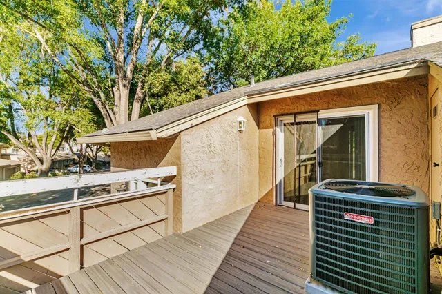 a view of a balcony with wooden floor and potted plants