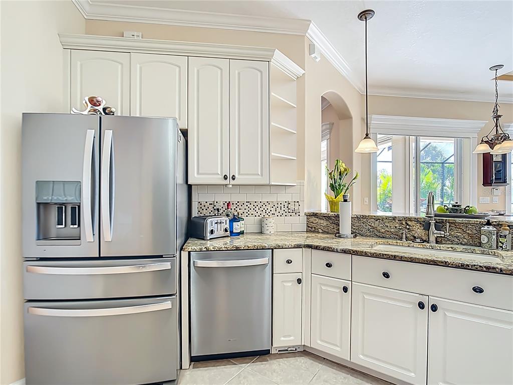 114 Rimini Way North Venice, FL 34275 - Photo 11 of 54 a kitchen with white cabinets and stainless steel appliances