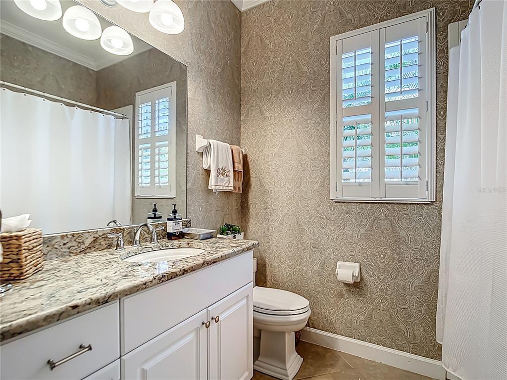 114 Rimini Way North Venice, FL 34275 - Photo 25 of 54 a bathroom with a granite countertop sink toilet a mirror and a window