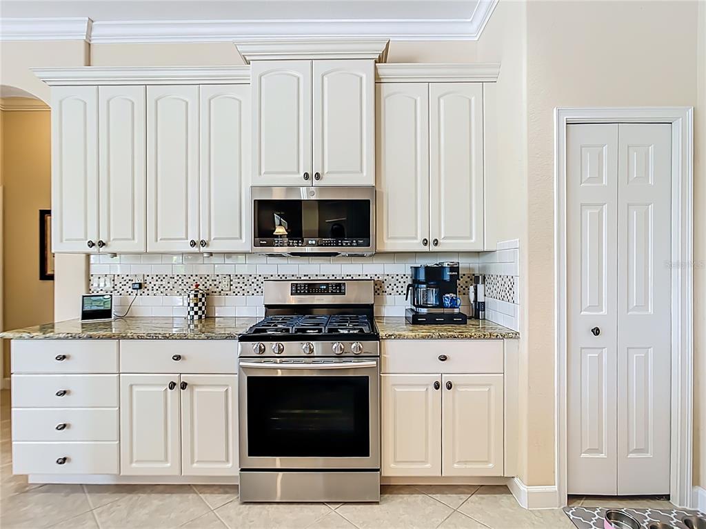 114 Rimini Way North Venice, FL 34275 - Photo 10 of 54 a kitchen with white cabinets and appliances