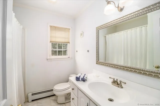 a bathroom with a sink a toilet and a mirror