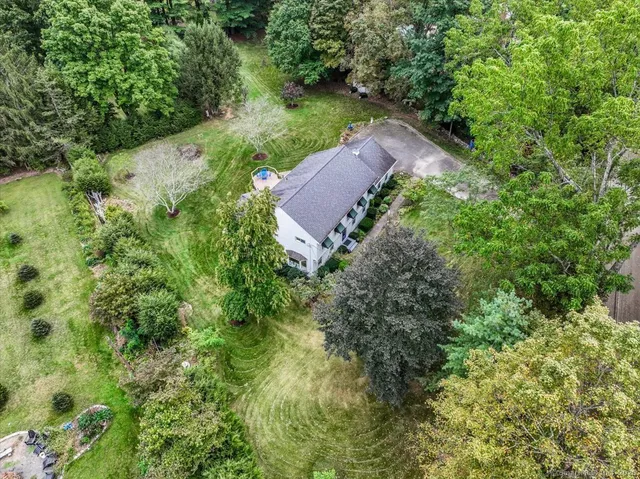 an aerial view of a house with a yard and lake view