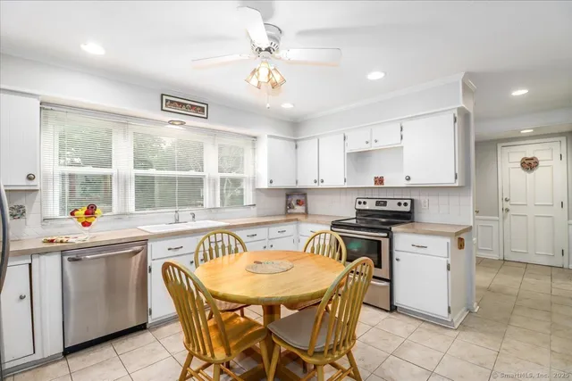 a kitchen with a stove a sink a dining table and chairs