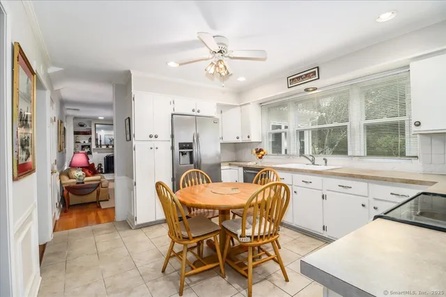 a kitchen with a dining table chairs and refrigerator