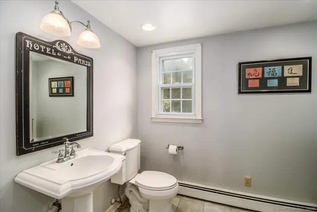 a bathroom with a sink a toilet and mirror