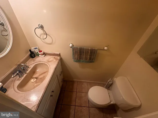 a bathroom with a granite countertop sink mirror vanity and toilet