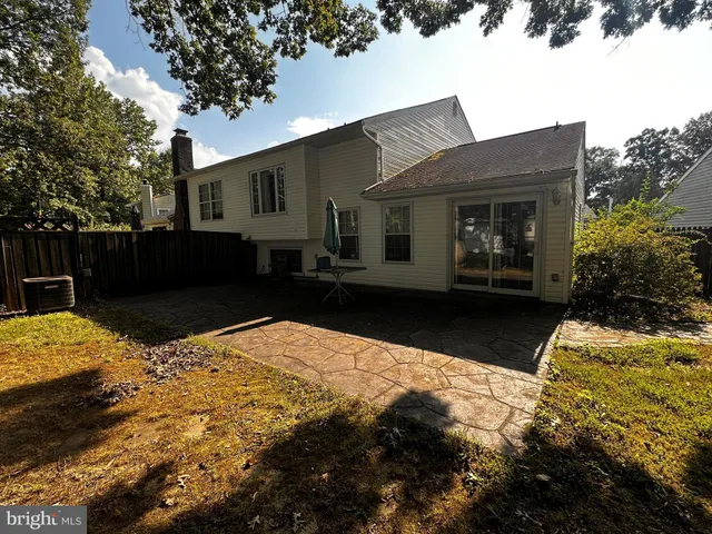 a view of a house with a yard and large tree