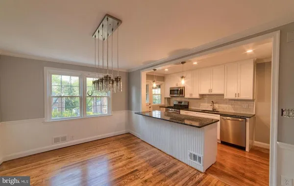 a kitchen with stainless steel appliances granite countertop a sink stove and wooden floor
