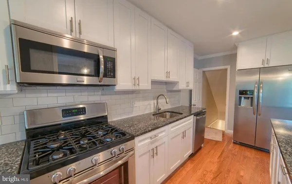 a kitchen with stainless steel appliances granite countertop a stove a microwave and a refrigerator