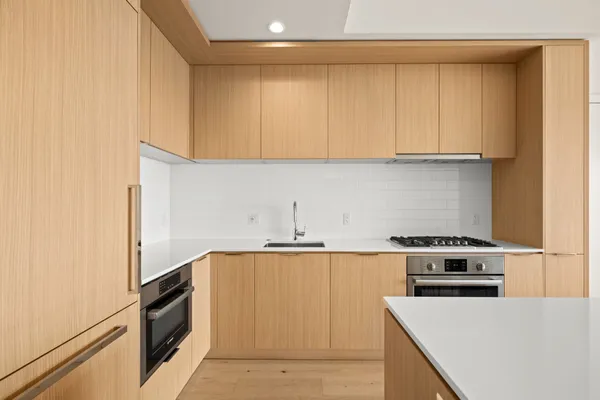 a kitchen with a sink a stove and cabinets