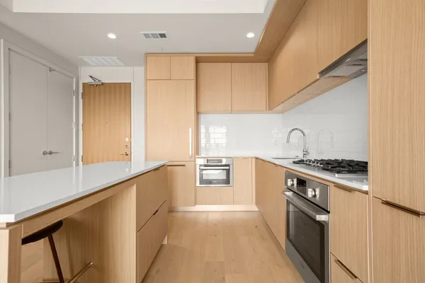 a kitchen with stainless steel appliances granite countertop a stove a sink and a refrigerator