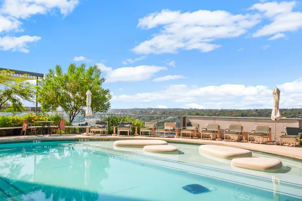 a view of swimming pool with outdoor seating and city view