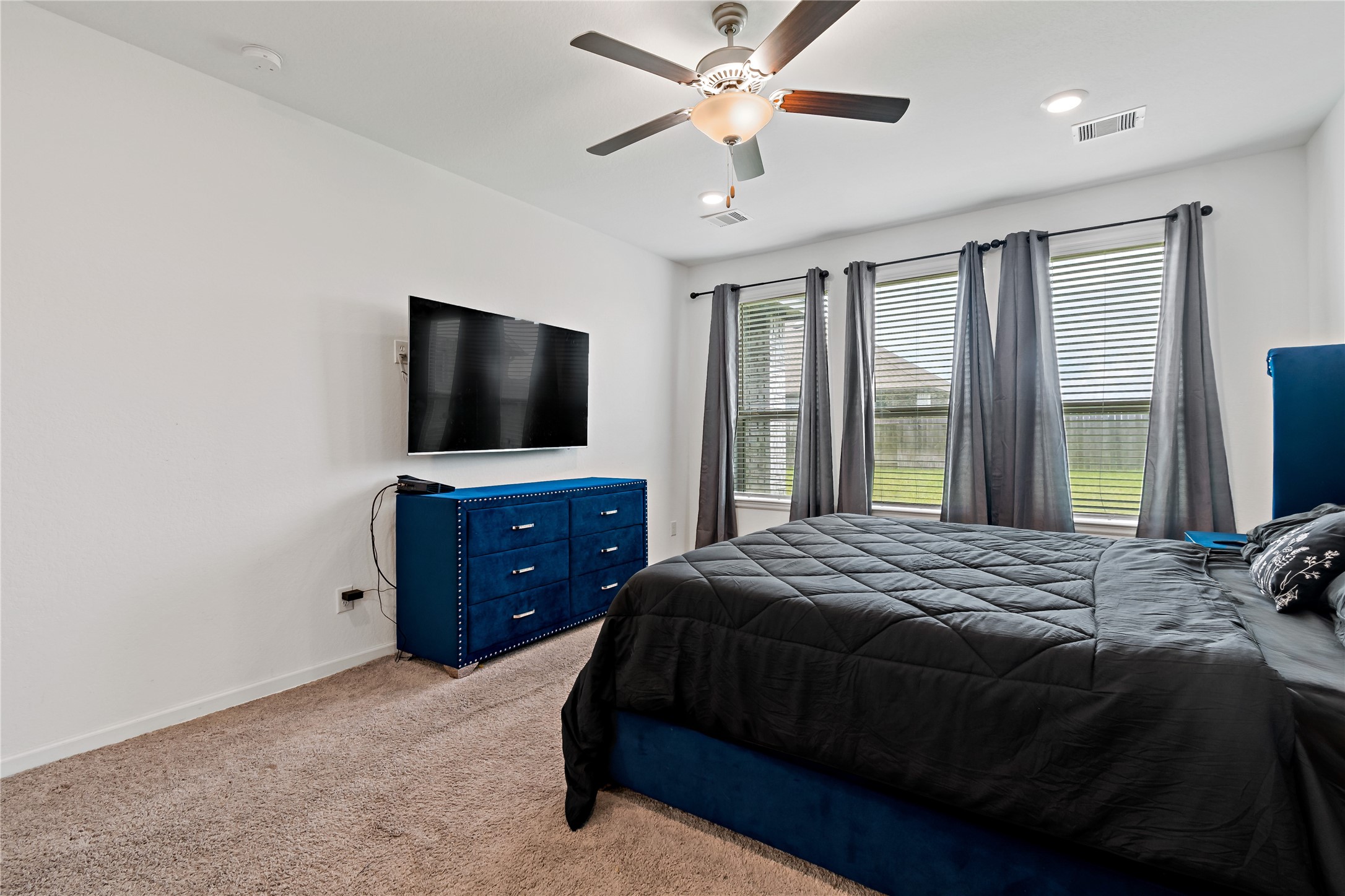 14010 Hartford Heights Way Rosharon, TX 77583 - Photo 7 of 30 a bedroom with a bed and a flat tv screen on dresser