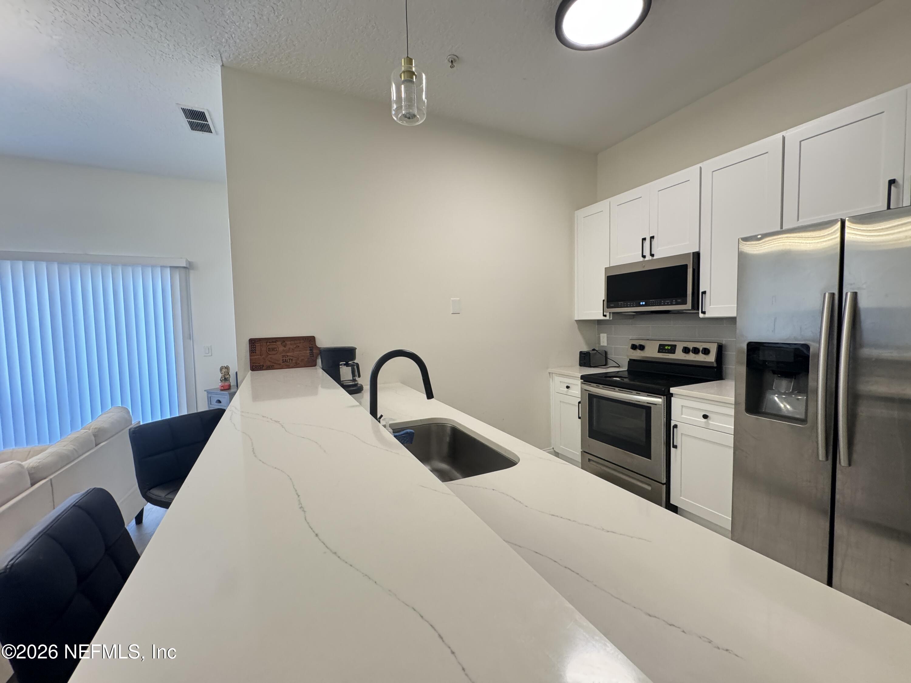 7920 Merrill Road, Unit 1205 Jacksonville, FL 32277 - Photo 9 of 25 Kitchen with Living Room