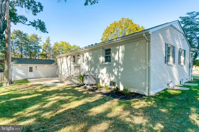 a view of a house with a big yard and large trees