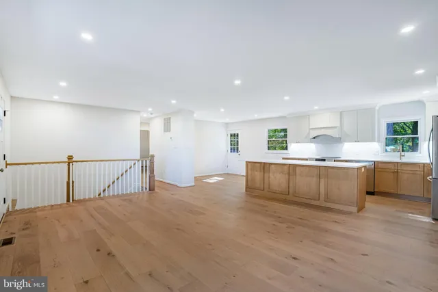 a kitchen with stainless steel appliances kitchen island granite countertop a stove a sink and a refrigerator