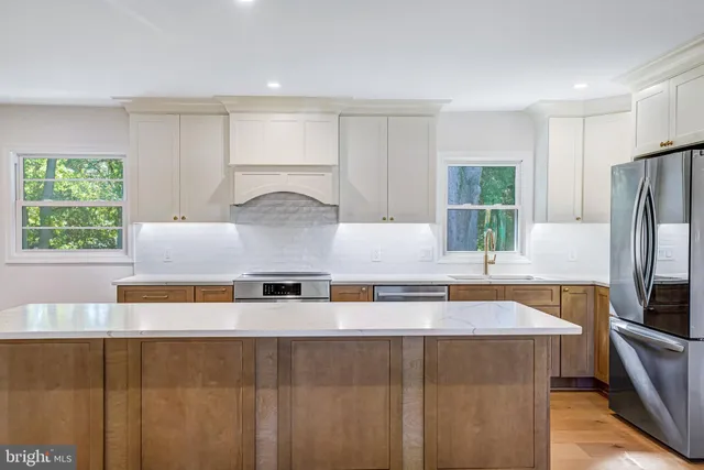 a kitchen with stainless steel appliances granite countertop a sink and a refrigerator