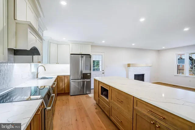 a large kitchen with stainless steel appliances a large counter top and a stove