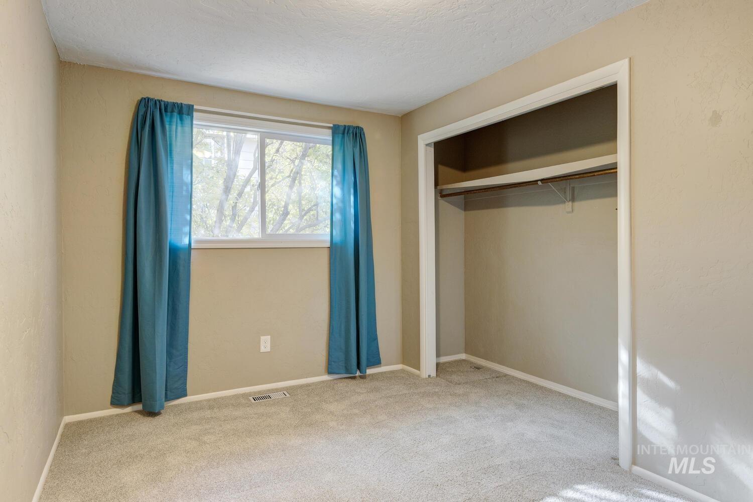 390 North Cleveland Avenue Kuna, ID 83634 - Photo 19 of 24 Unfurnished bedroom with carpet flooring, a closet, and a textured ceiling