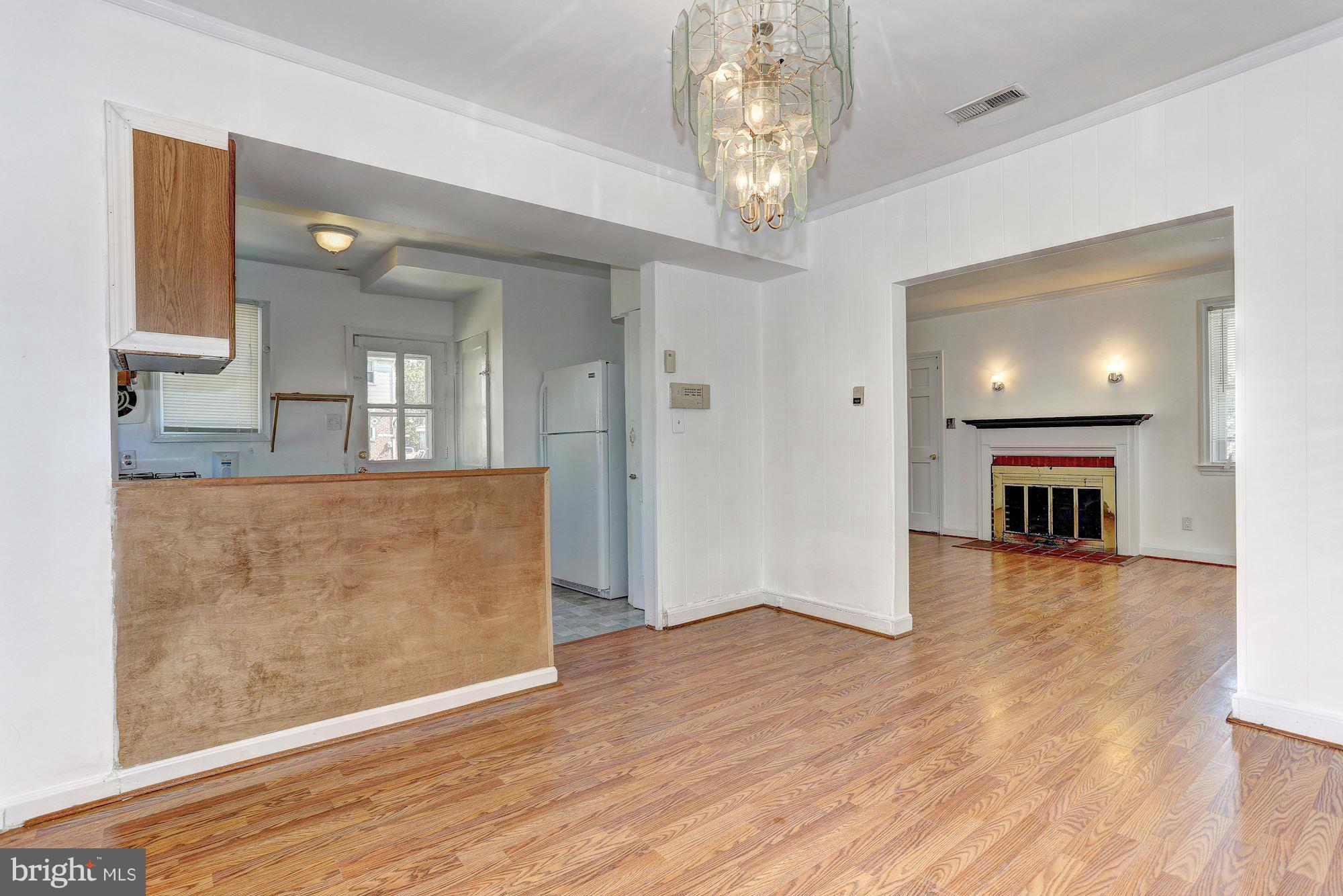 3127 Dunglow Road Baltimore, MD 21222 - Photo 5 of 14 an empty room with wooden floor and fireplace