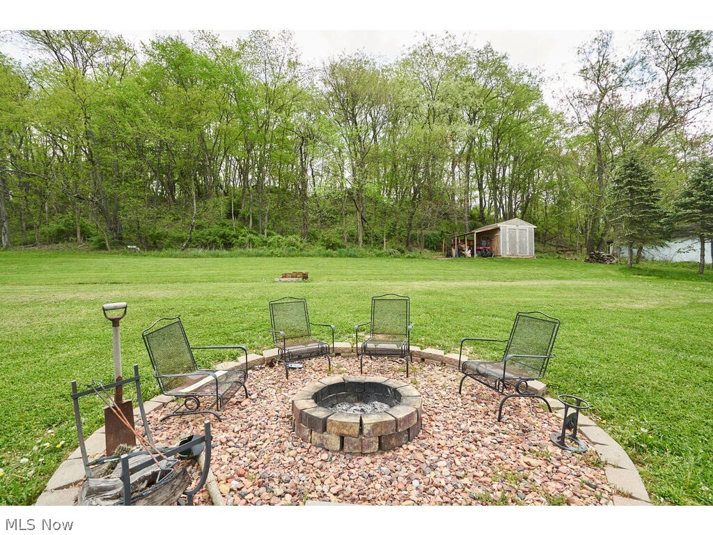 5763 Ruslin Hills Road Dover, OH 44622 - Photo 13 of 17 View of yard with an outdoor fire pit and a shed