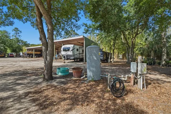 a view of a backyard with table and chairs and a large tree