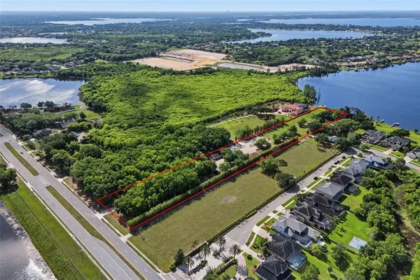 an aerial view of a residential houses with a yard and lake view