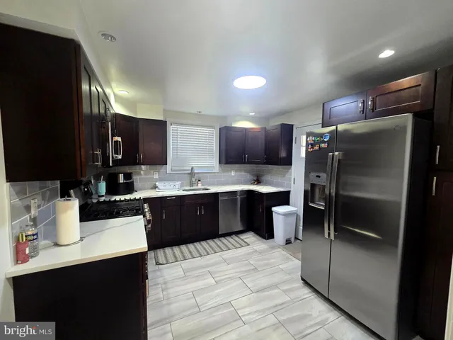a kitchen with a refrigerator sink and wooden cabinets