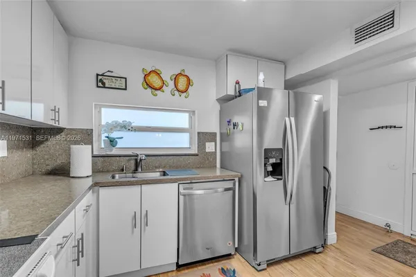 a kitchen with stainless steel appliances granite countertop a refrigerator and a stove