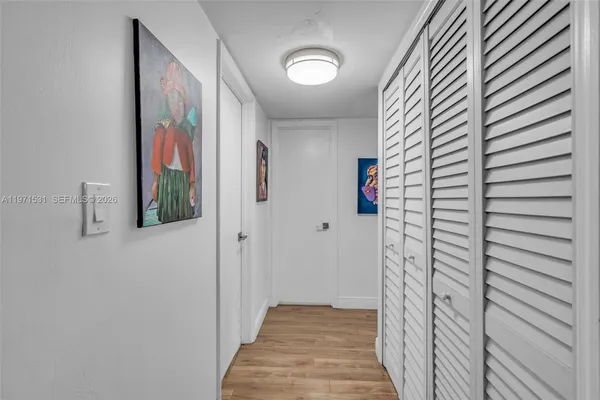 a view of a hallway with wooden floor and windows