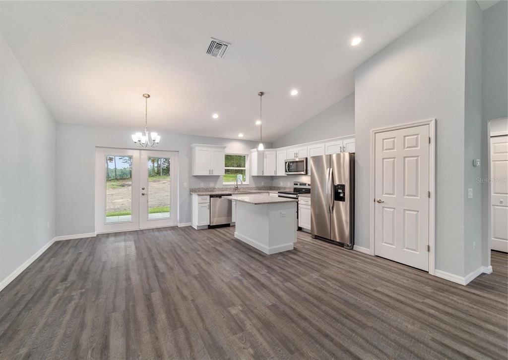 15673 Southwest 37th Circle Ocala, FL 34473 - Photo 3 of 19 an open kitchen with a refrigerator and wooden floor