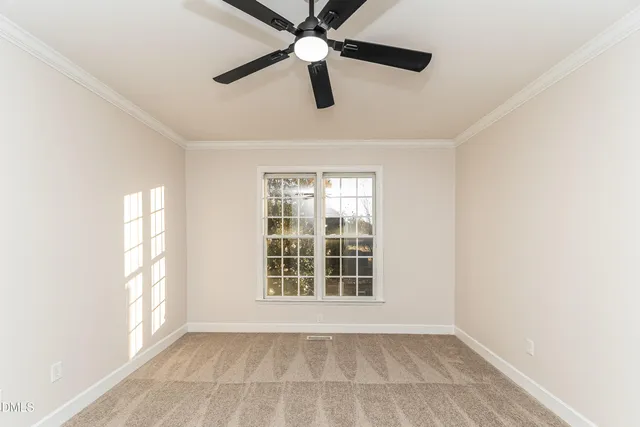 an empty room with windows and ceiling fan