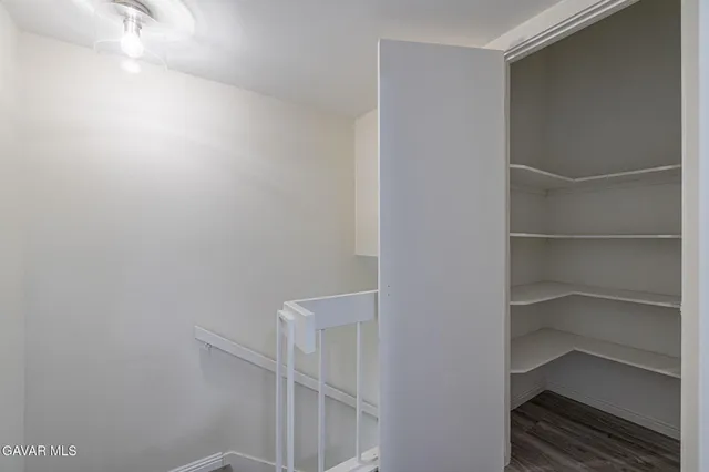 a view of walk in closet with empty racks