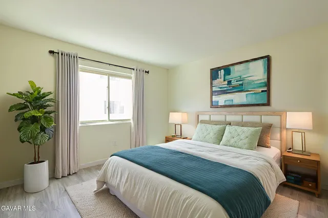 a bedroom with a large bed and a potted plant