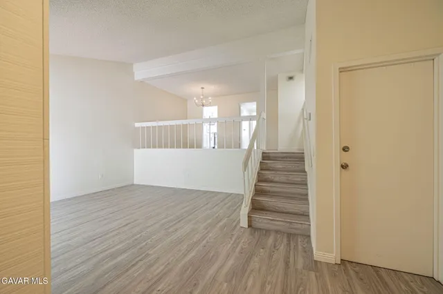 a view of a hallway with wooden floor and entryway
