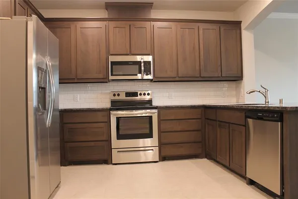 a kitchen with a refrigerator stove and microwave