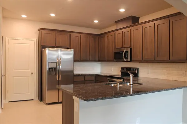 a kitchen with kitchen island a sink stainless steel appliances and cabinets